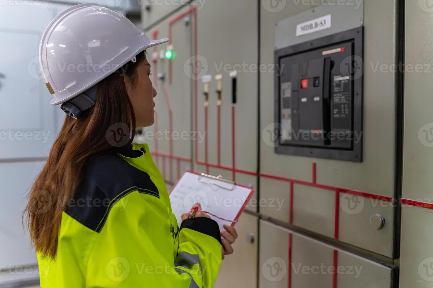 Asian electric engineer holding clipboard for checking and monitoring the electrical system in the control room,Technician thailand people working photo