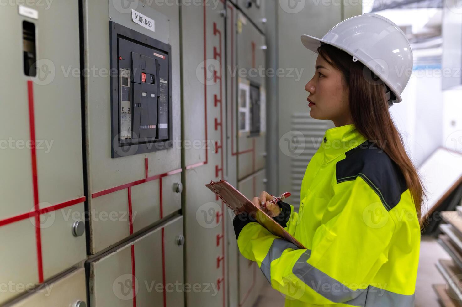 Asian electric engineer holding clipboard for checking and monitoring the electrical system in the control room,Technician thailand people working photo