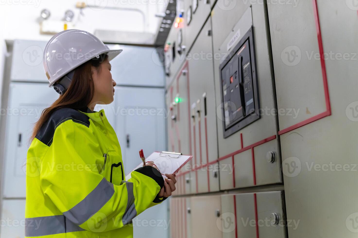 Asian electric engineer holding clipboard for checking and monitoring the electrical system in the control room,Technician thailand people working photo