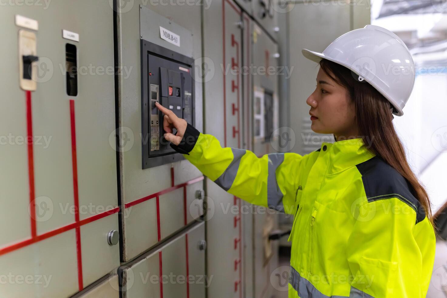 Asian electric engineer holding clipboard for checking and monitoring the electrical system in the control room,Technician thailand people working photo