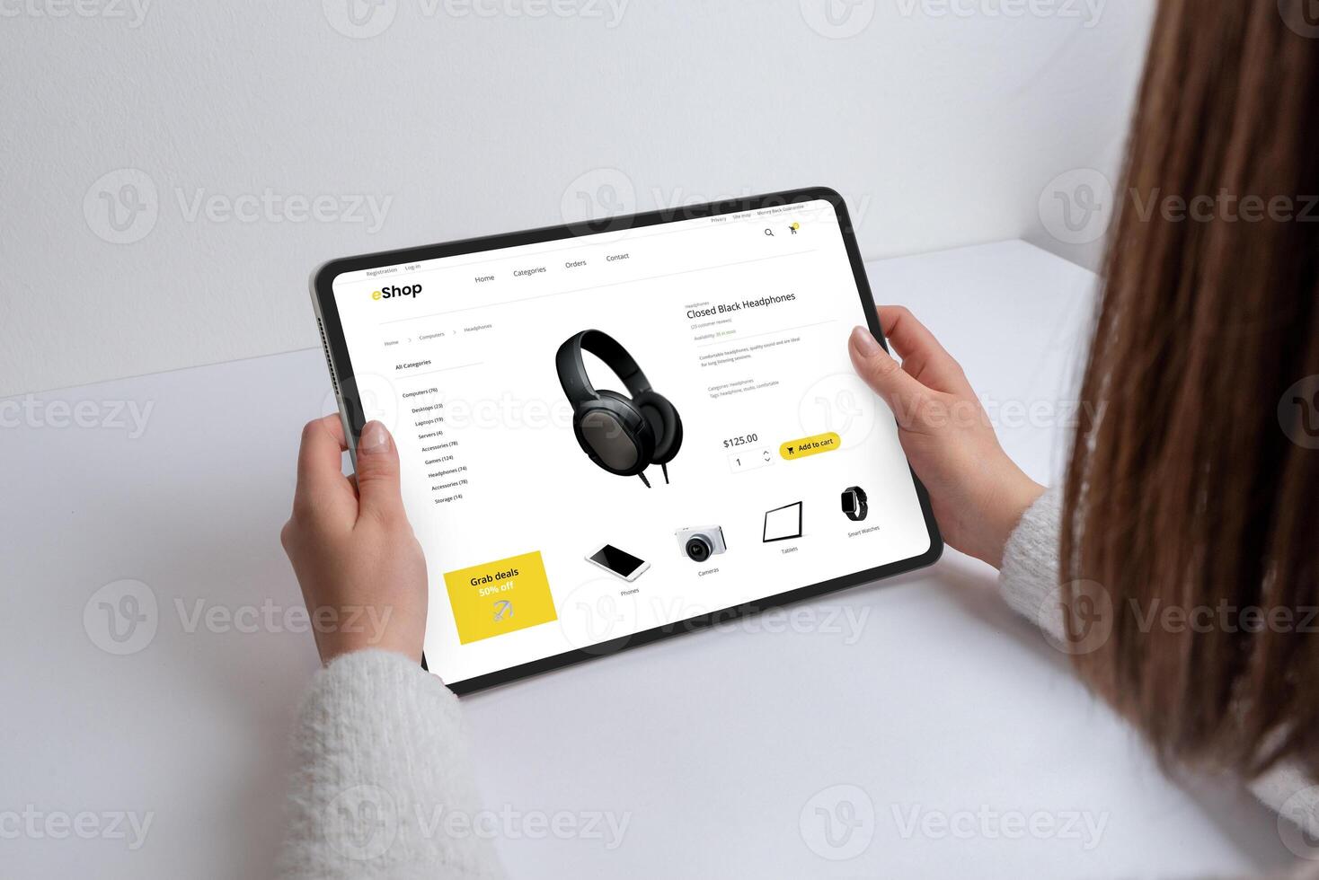 Girl shops online for headphones, gadgets, and devices on a modern e-commerce webpage using a tablet. Seamless tech browsing for the latest devices and accessories photo