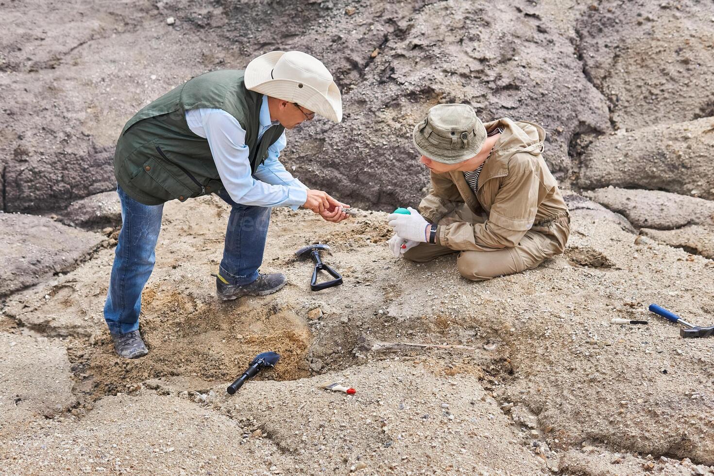 arqueólogos o paleontólogos en un campo expedición discutir encontró antiguo huesos foto