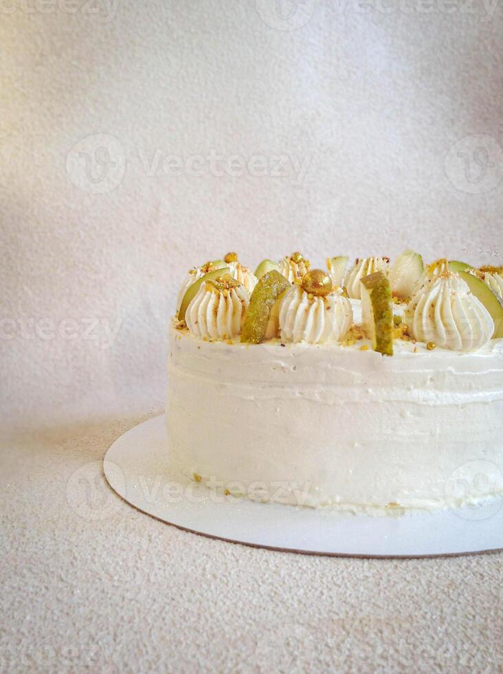 White cake with white cream and slices of pear, side view photo