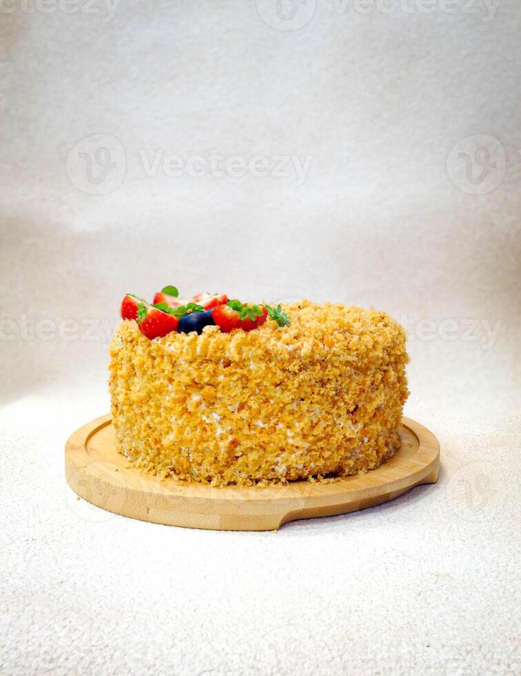 Cake with strawberries and blueberries on a wooden plate on a white background photo