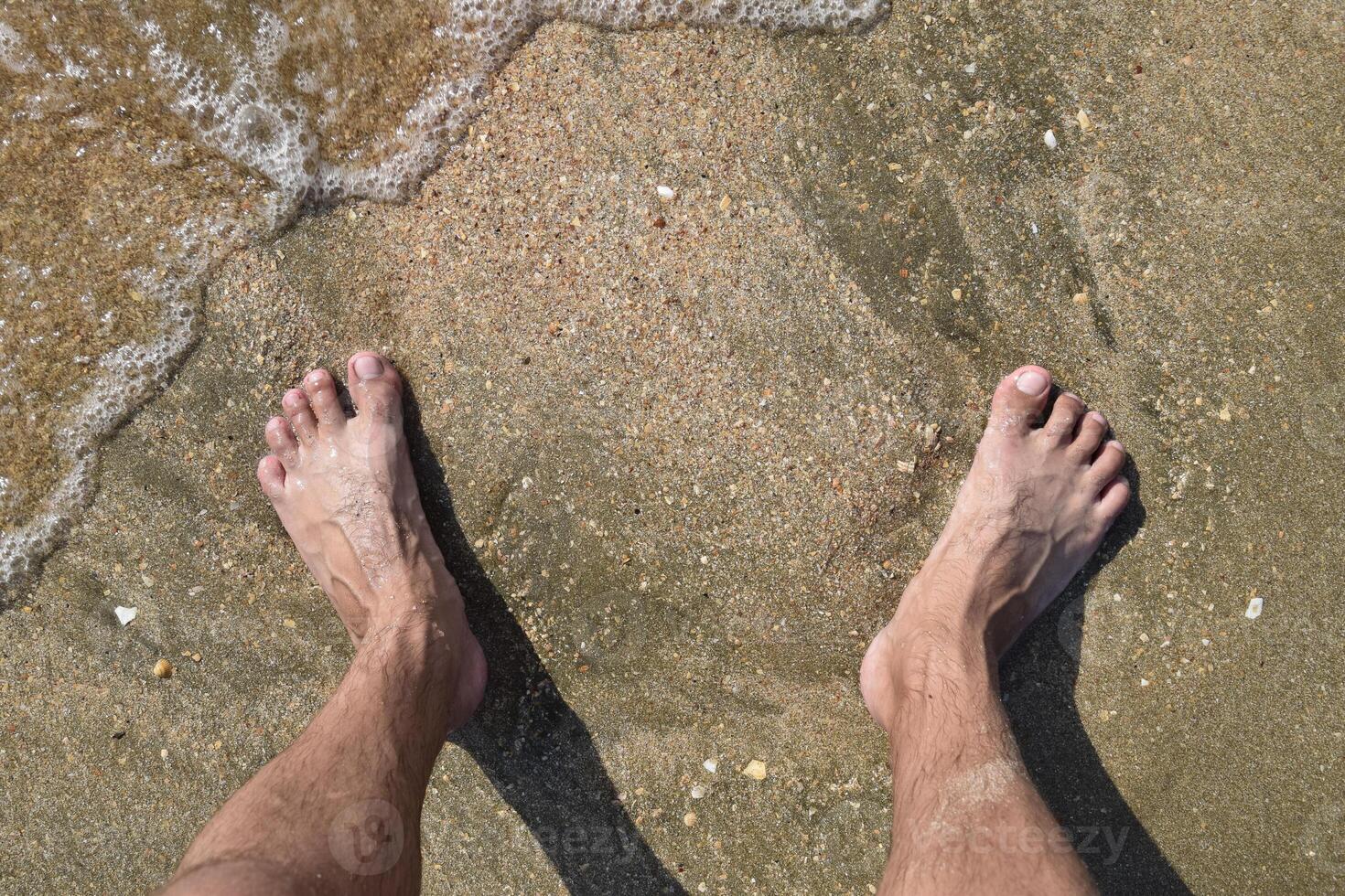 piernas hombres en el mar arena cerca mar ola foto