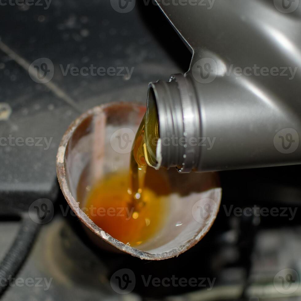 petróleo cambio en el motor de el coche. relleno el petróleo mediante el embudo. coche mantenimiento estación. foto