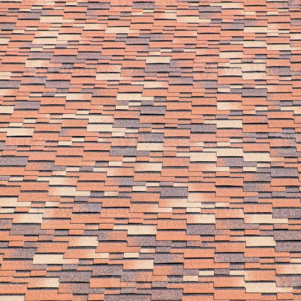 Roof from multi-colored bituminous shingles. Patterned bitumen shingles. photo