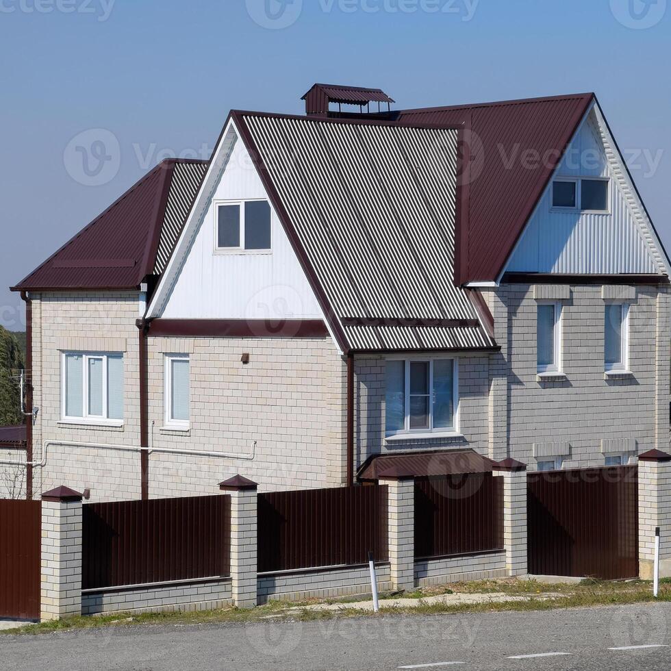 The house is with an attic and a combined roof. photo