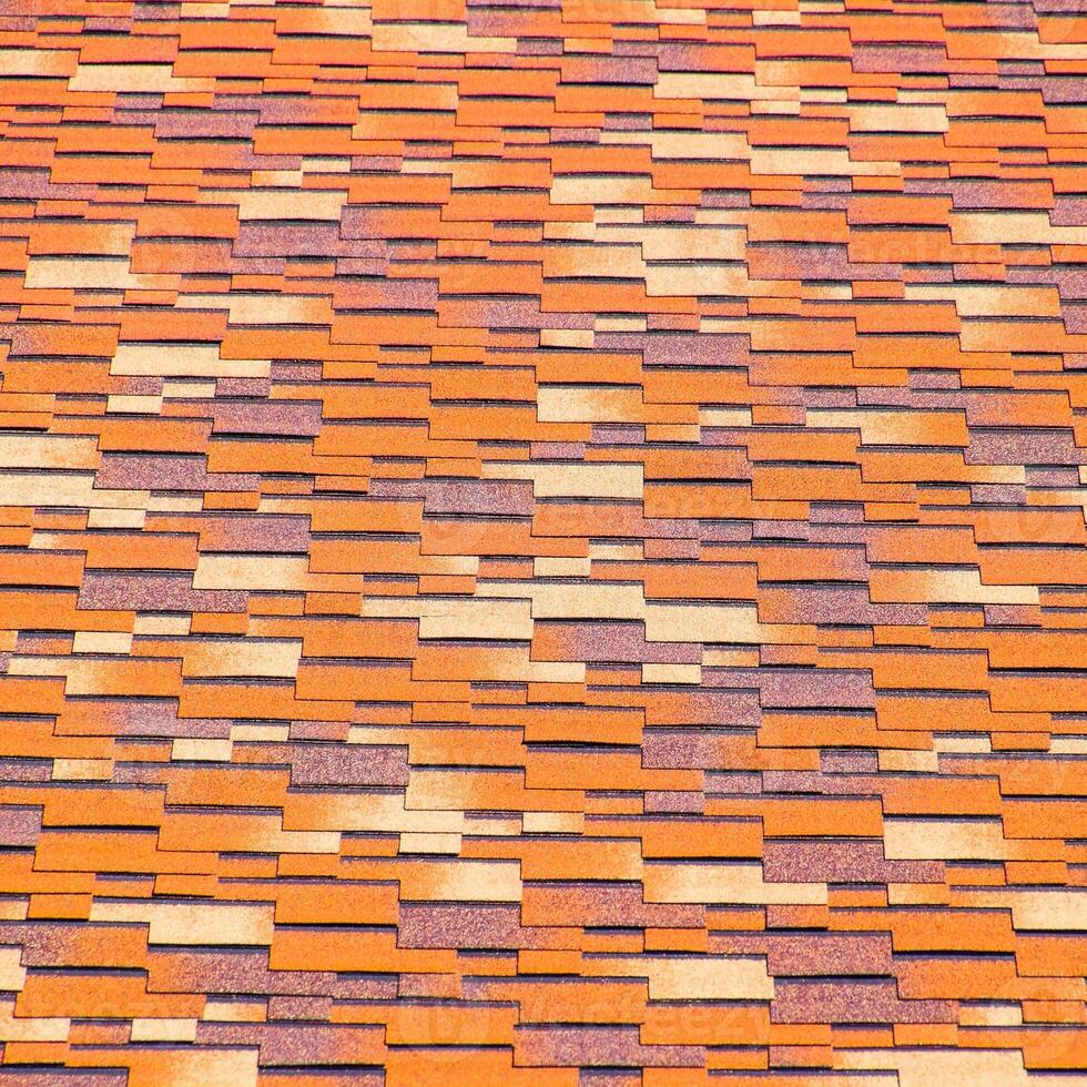 Roof from multi-colored bituminous shingles. Patterned bitumen shingles. photo