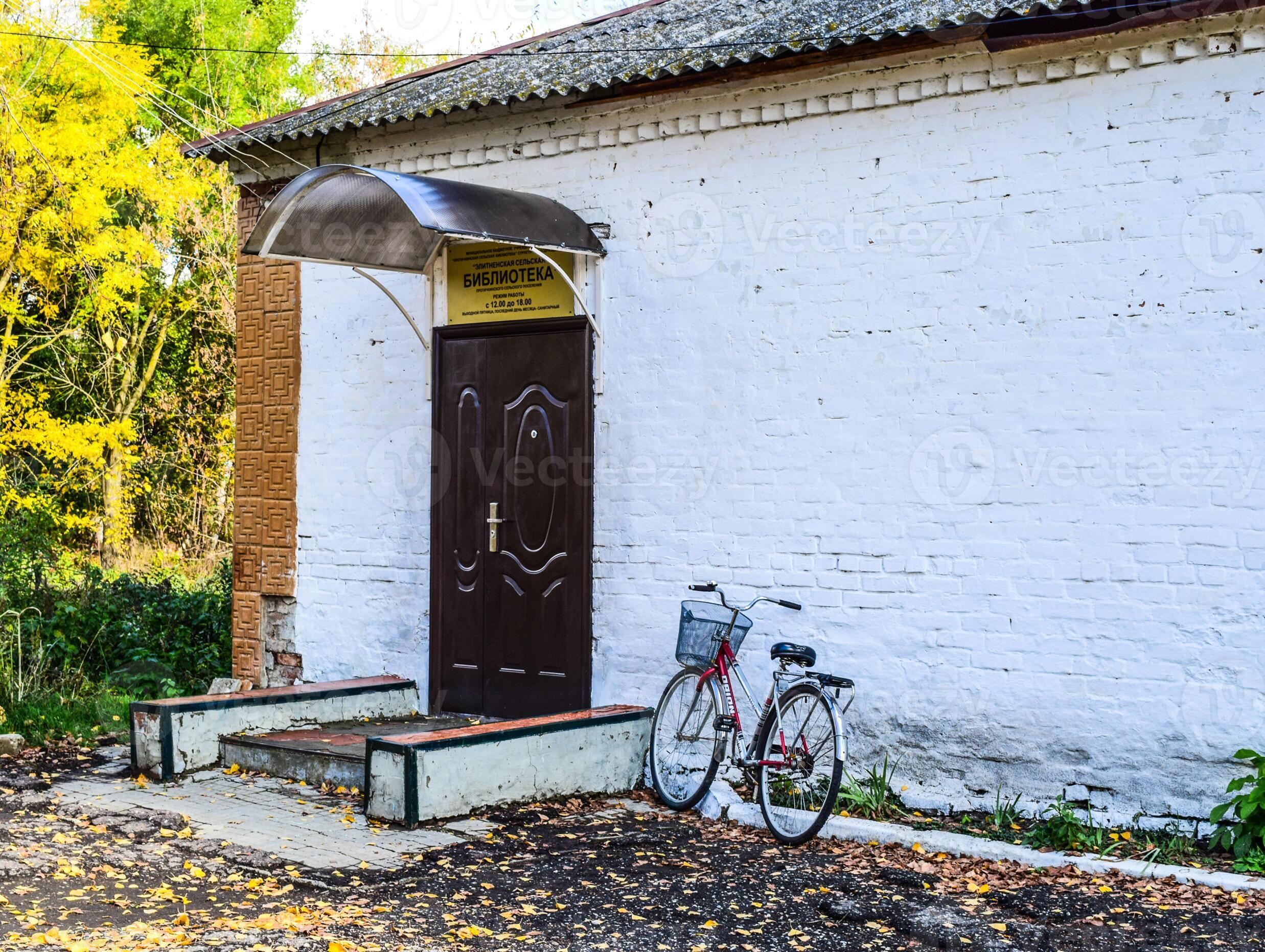 Rural library outside. Bicycle visitor library. The old Soviet building ...