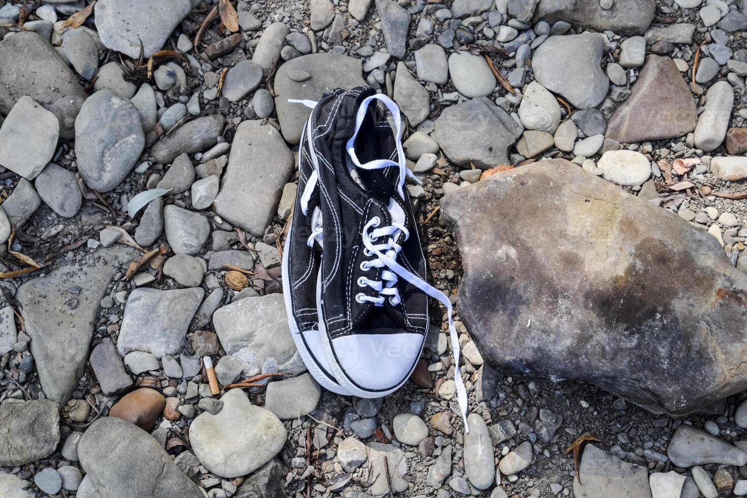 Black and white sneakers on stones. Sport shoes. photo