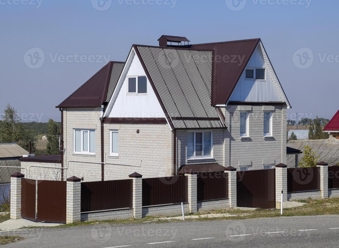 The house is with an attic and a combined roof. photo