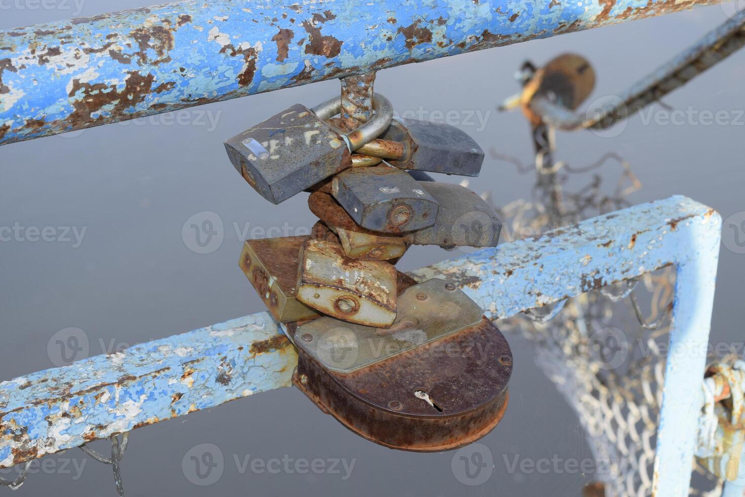 Love locks hung by newlyweds and lovers on the fence near the river. A symbol of strong relationships and eternal love photo