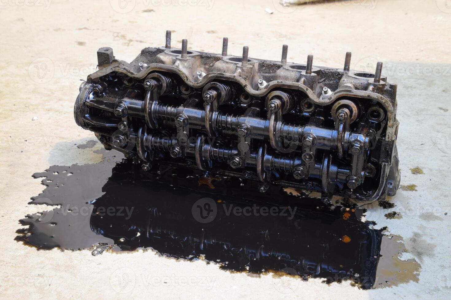 The head of the block of cylinders. The head of the block of cylinders removed from the engine for repair. Parts in engine oil. Car engine repair in the service photo