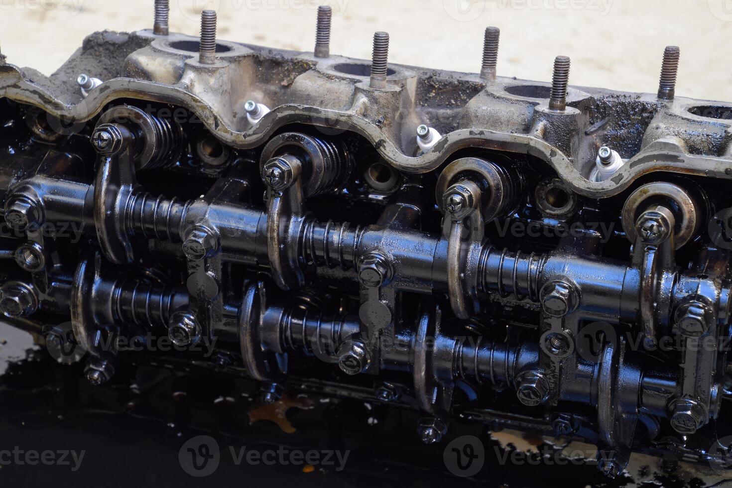 The head of the block of cylinders. The head of the block of cylinders removed from the engine for repair. Parts in engine oil. Car engine repair in the service photo