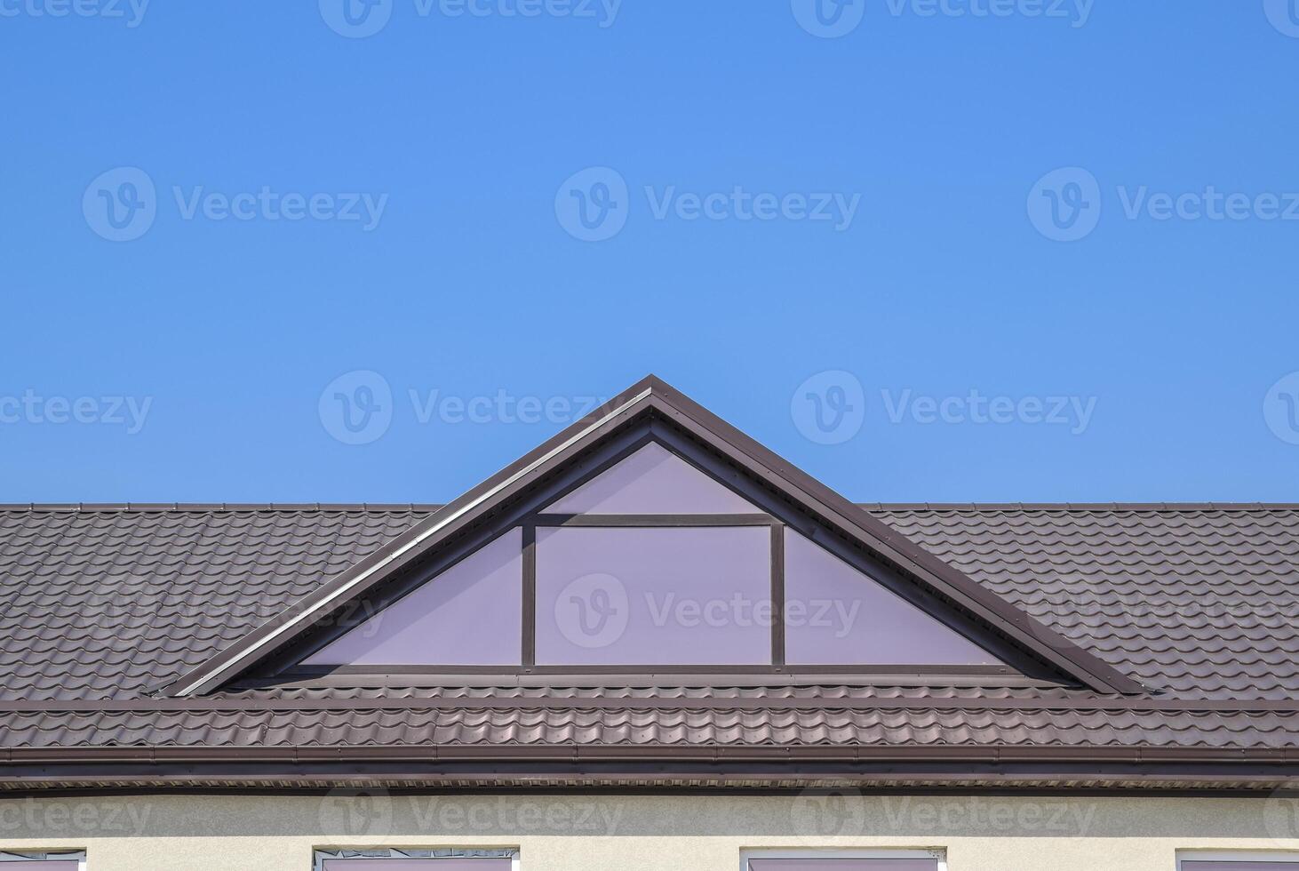 House with plastic windows and a brown roof of corrugated sheet photo