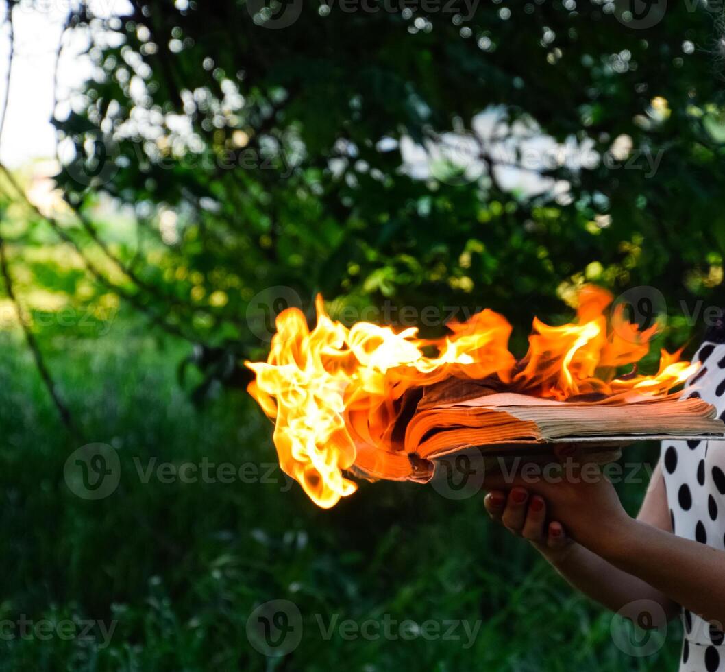 Burning book in the hands. Burning books in the forest. photo