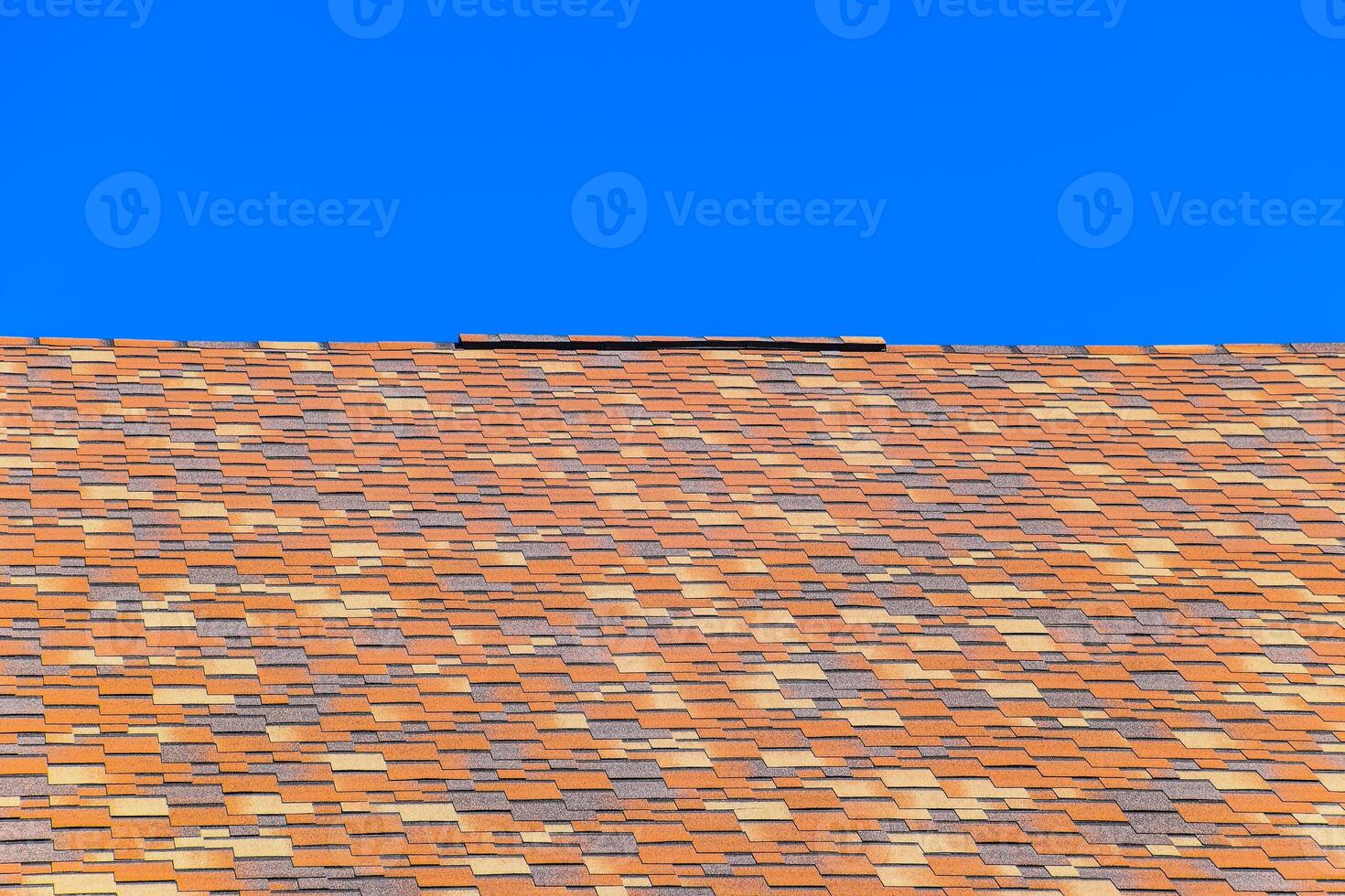 Roof from multi-colored bituminous shingles. Patterned bitumen shingles. photo
