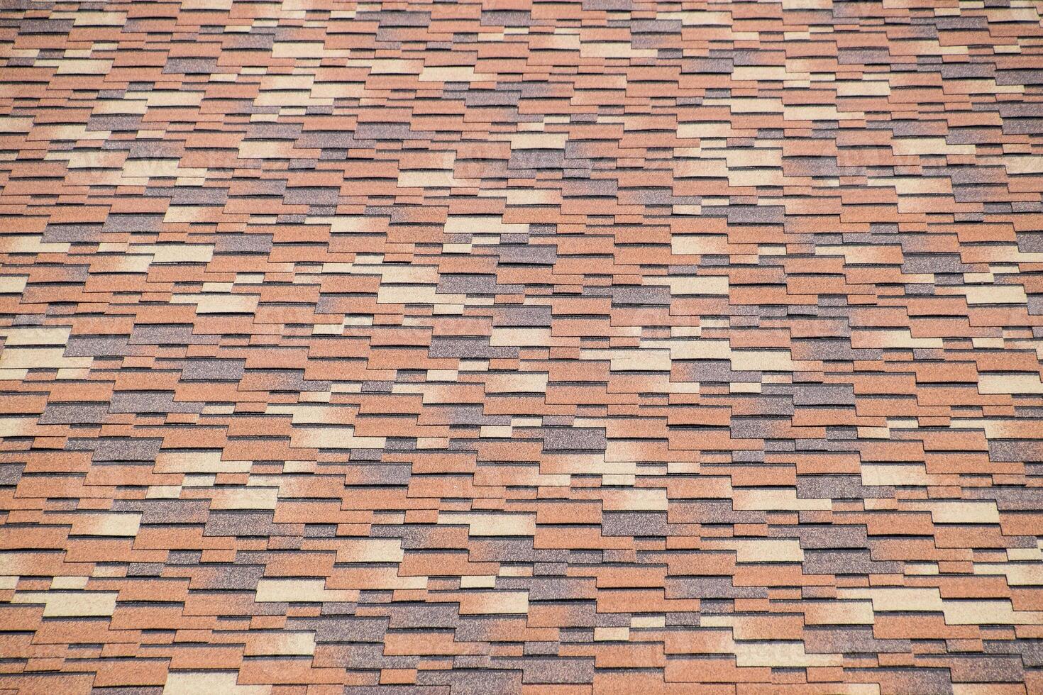 Roof from multi-colored bituminous shingles. Patterned bitumen shingles. photo