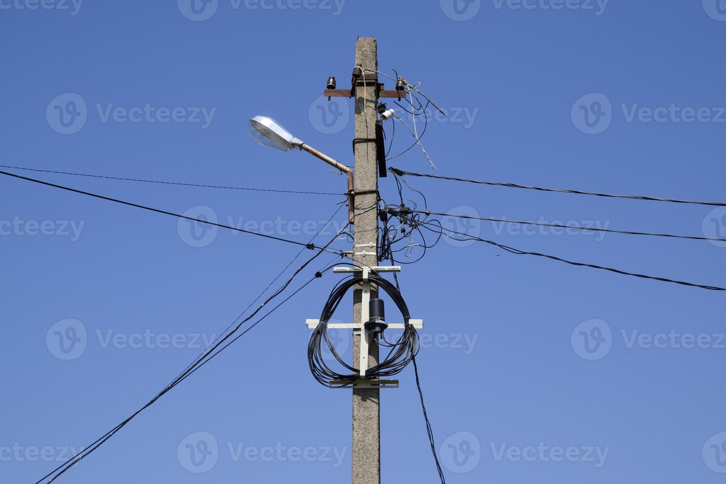 A pole with a lantern and coiled wires. photo