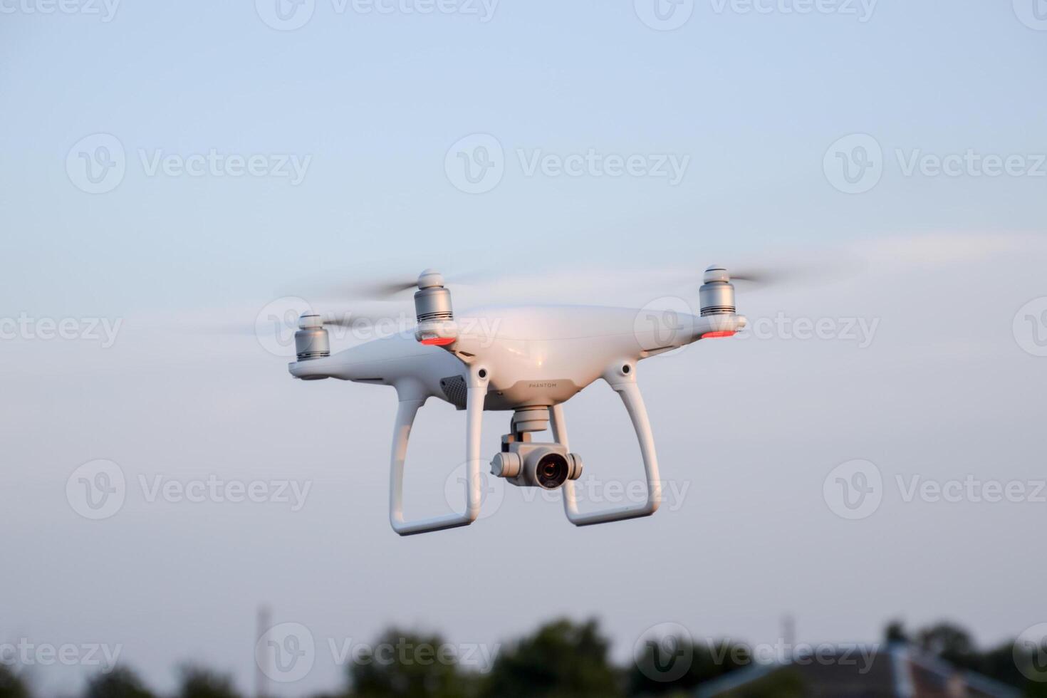 The drone, hovering in the air against the treetops photo
