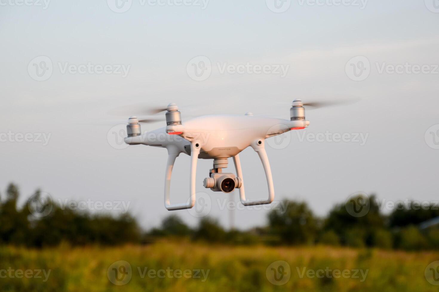 The drone, hovering in the air against the treetops photo
