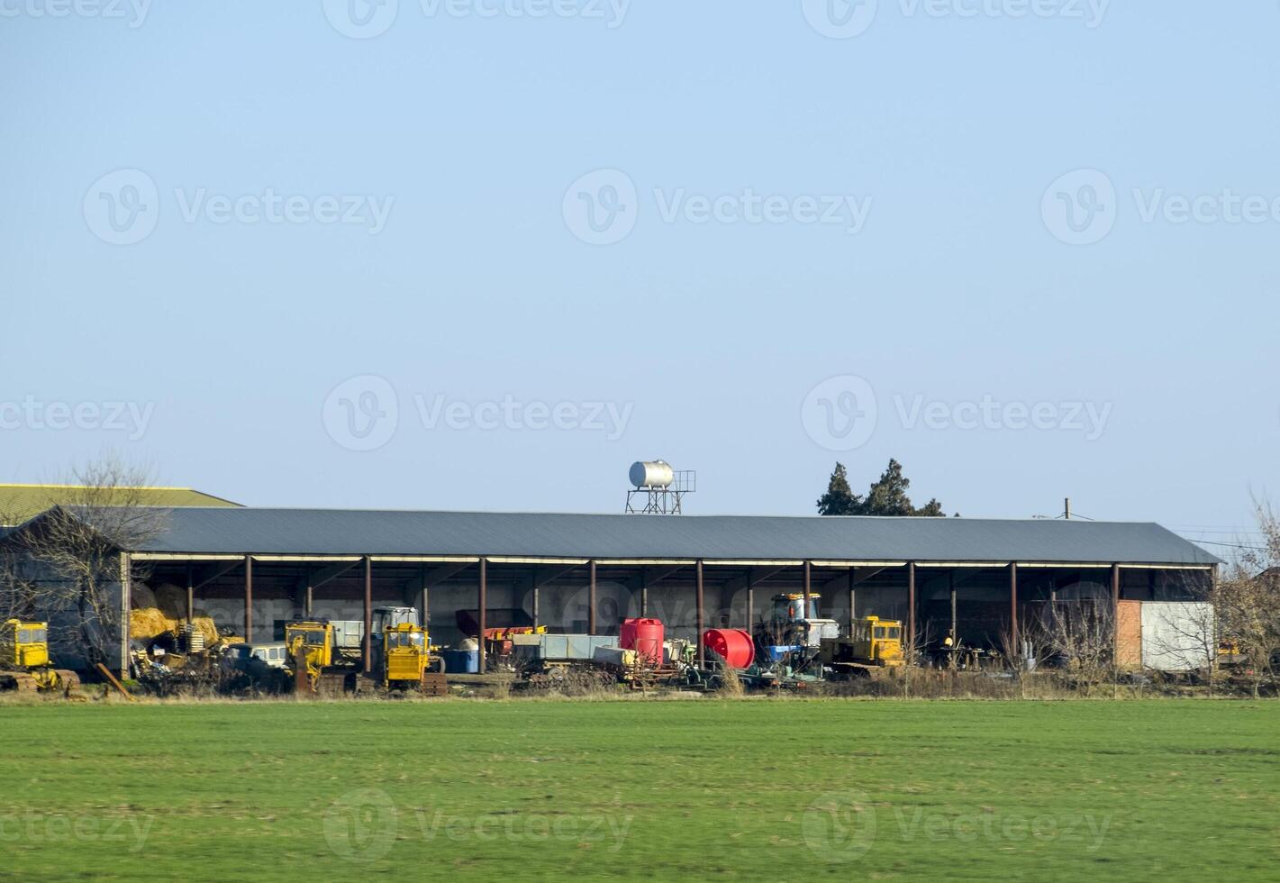 Tractors and other equipment under the awning in the garage. photo