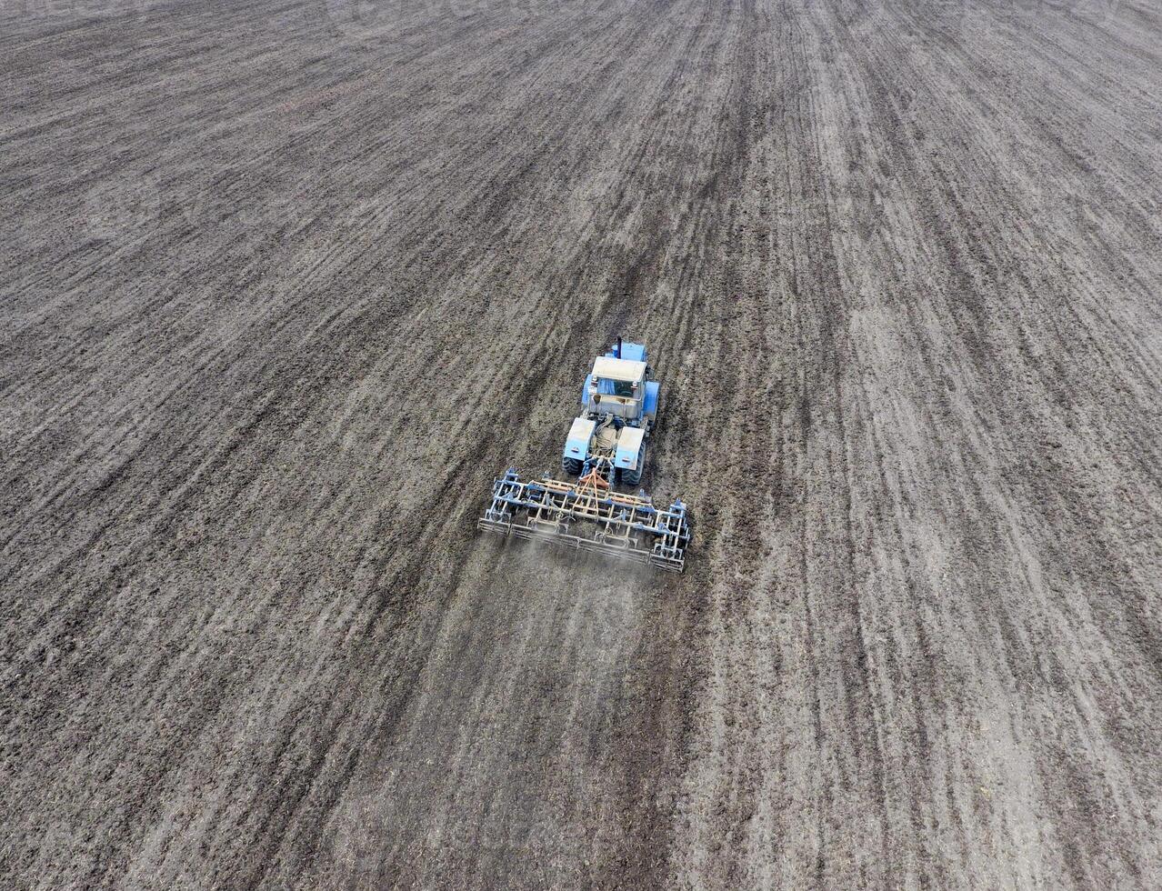 Cultivation of soil for the sowing of cereals. Tractor plows the soil on the field photo