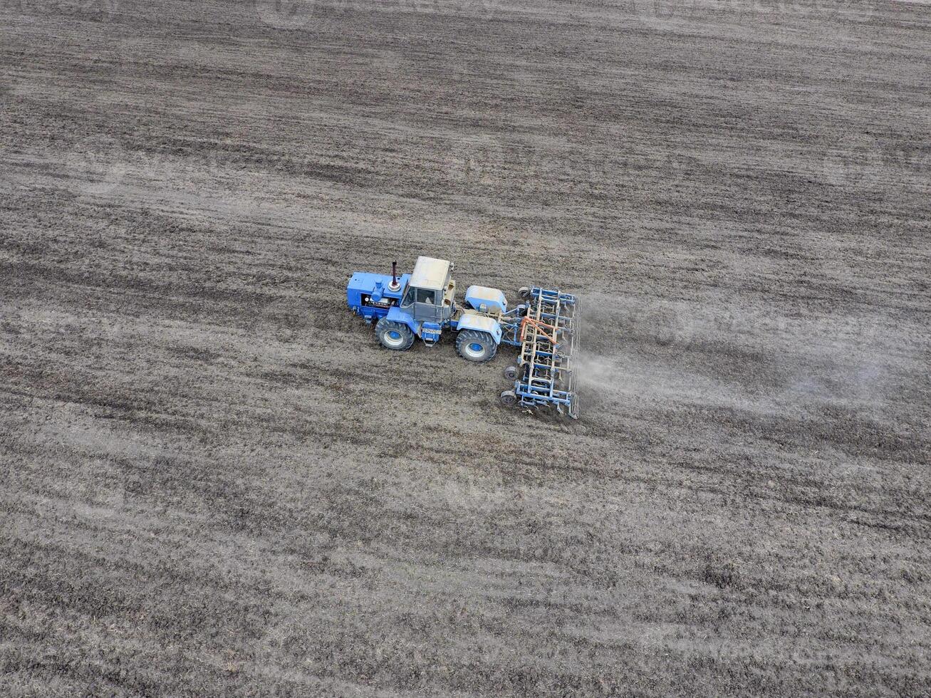 Cultivation of soil for the sowing of cereals. Tractor plows the soil on the field photo