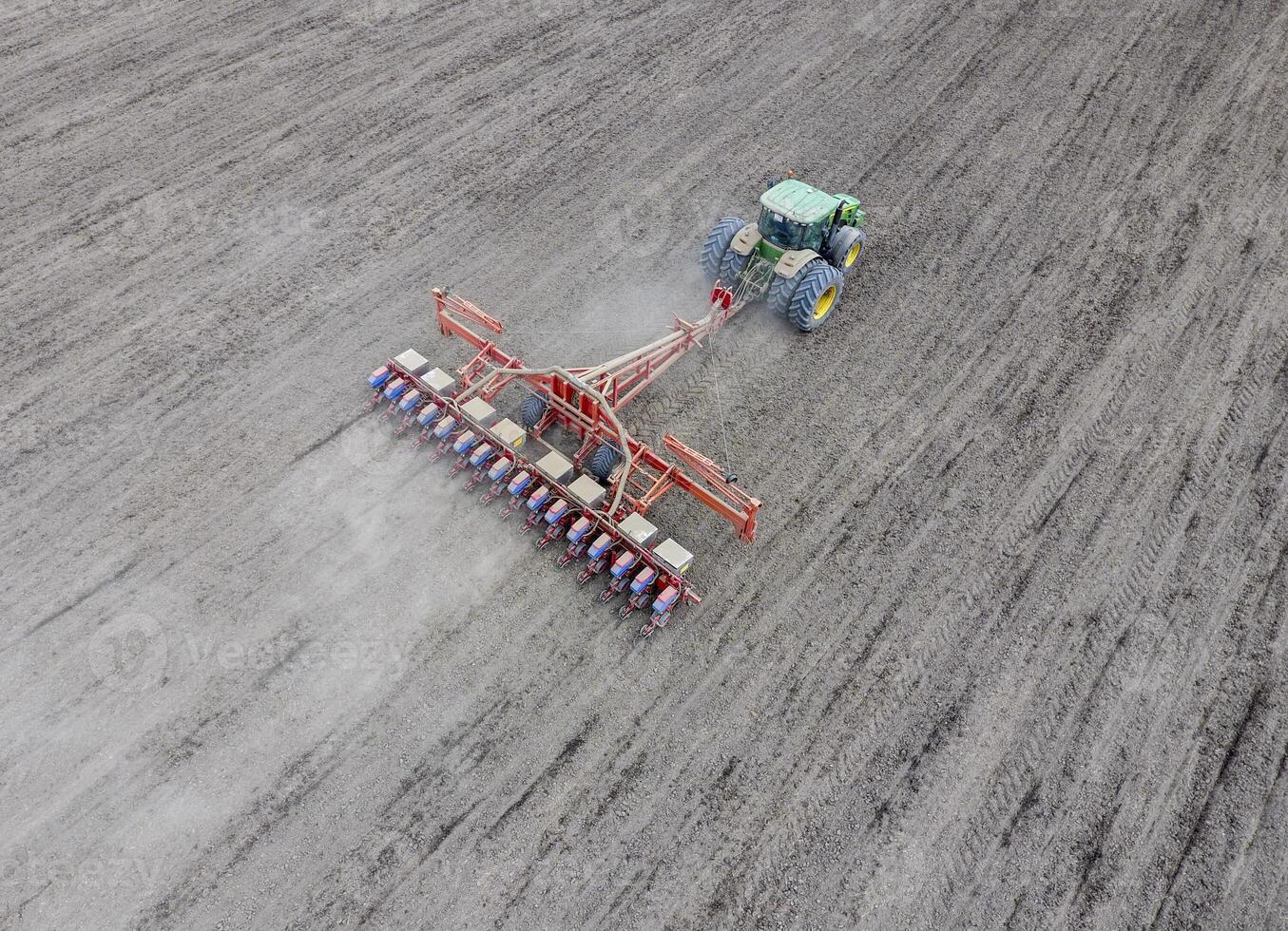 Sowing of corn. Tractor with a seeder on the field. Using a seeder for planting corn. photo