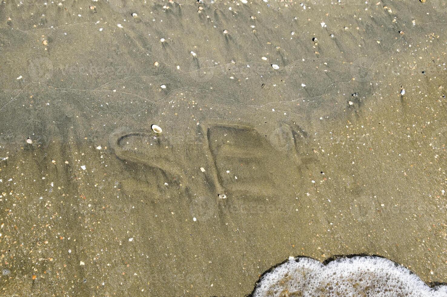 The inscription of the sea on the sand. Coastal sand and waves. Inscriptions on the shore photo