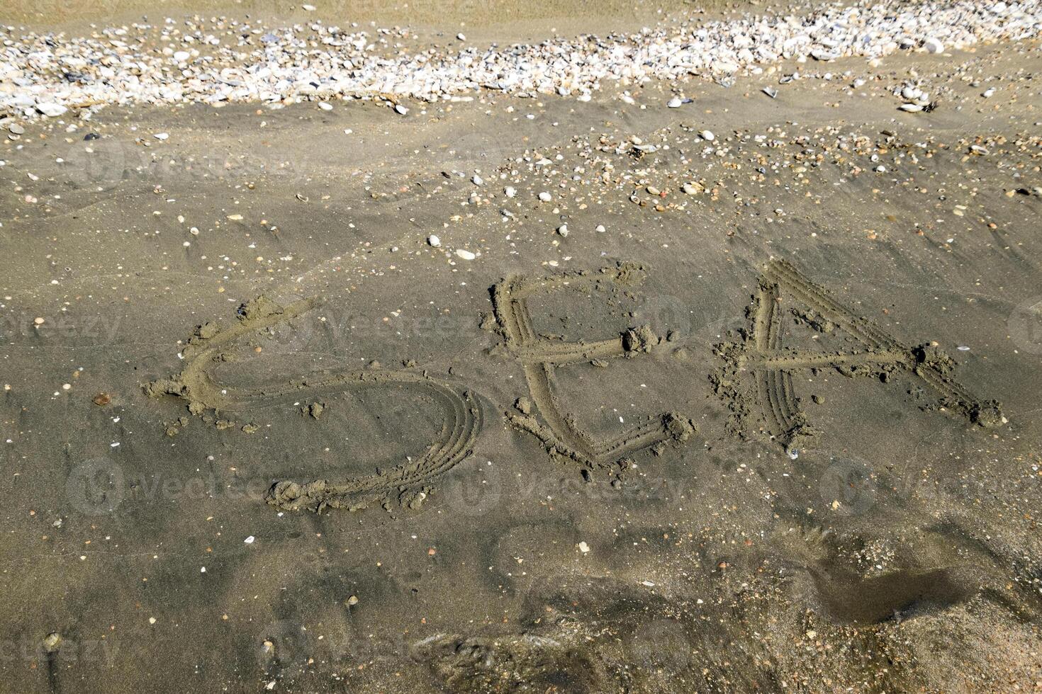 el inscripción de el mar en el arena. costero arena y ondas. inscripciones en el apuntalar foto