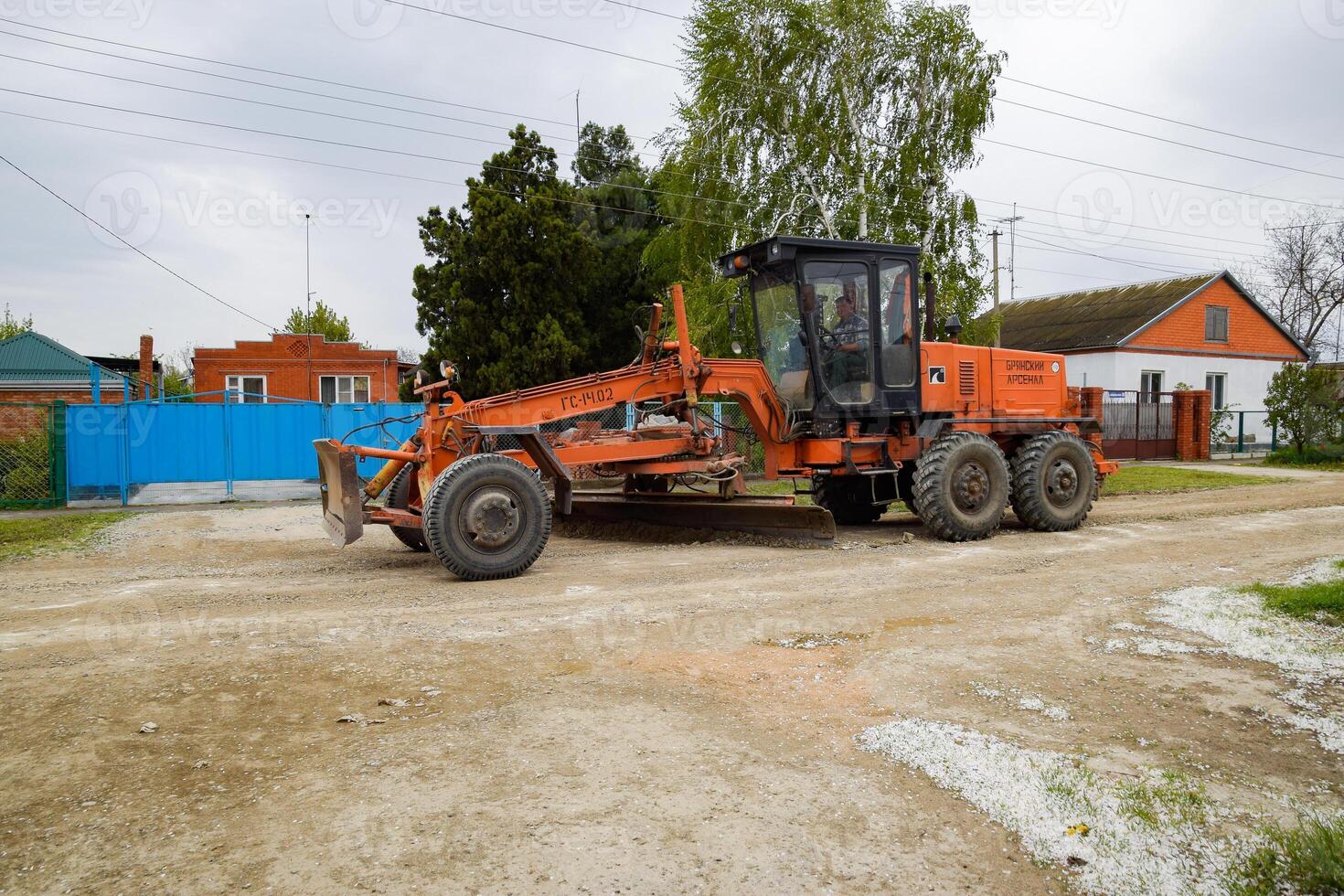 Grader on a dirt gravel road. Street repair by adding rubble. photo