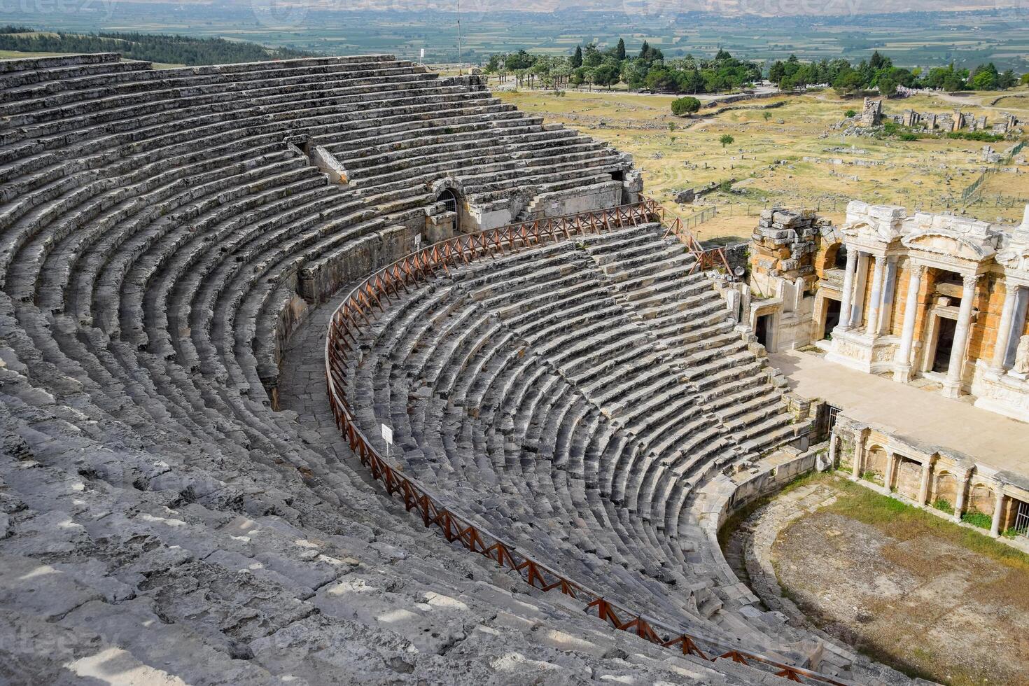 Ancient antique amphitheater in city of Hierapolis in Turkey. Steps and antique statues with columns in the amphitheater photo
