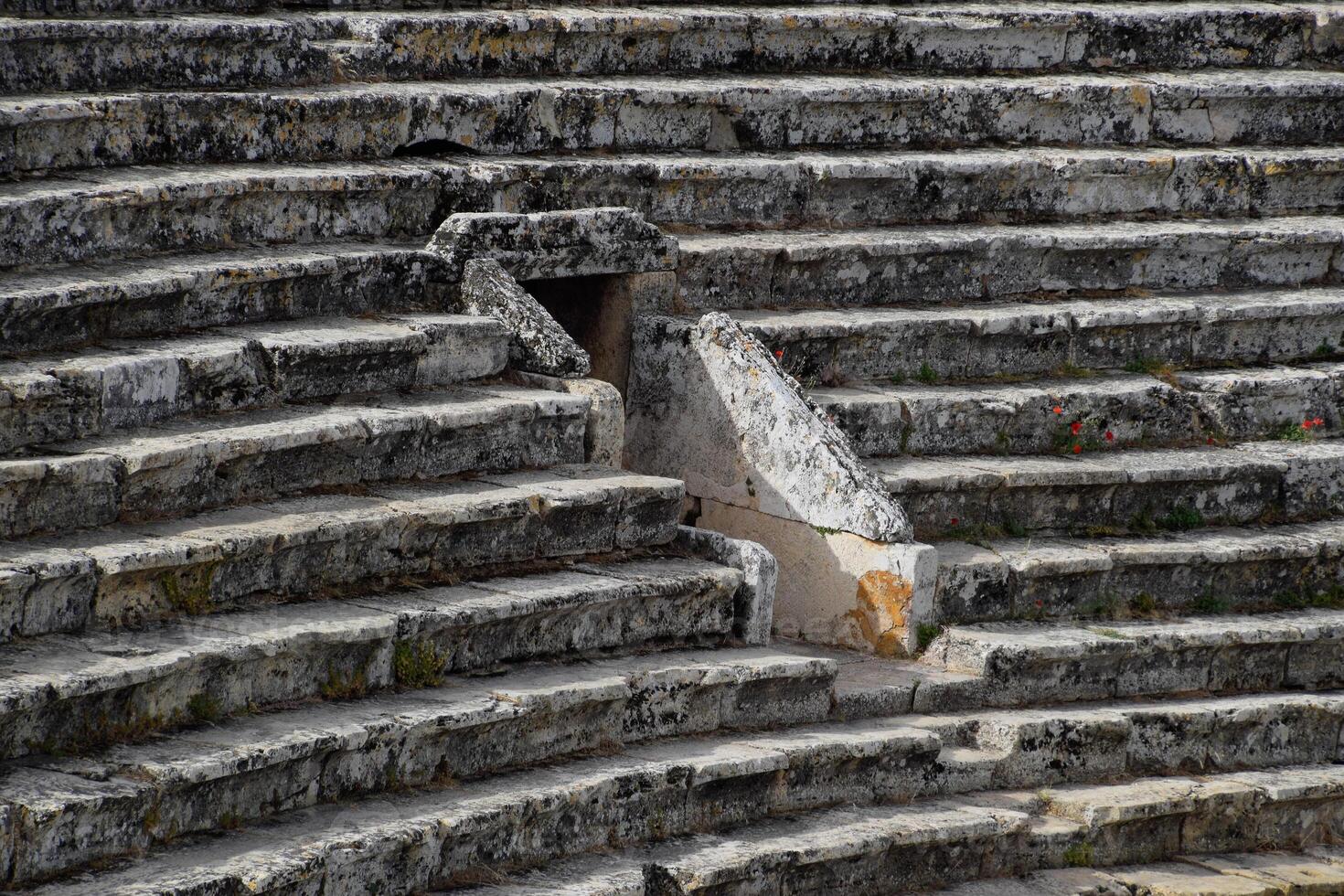 The steps of the amphitheater. Stone limestone and marble. Ancient antique amphitheater in city of Hierapolis in Turkey. Steps and antique statues with columns in the amphitheater photo