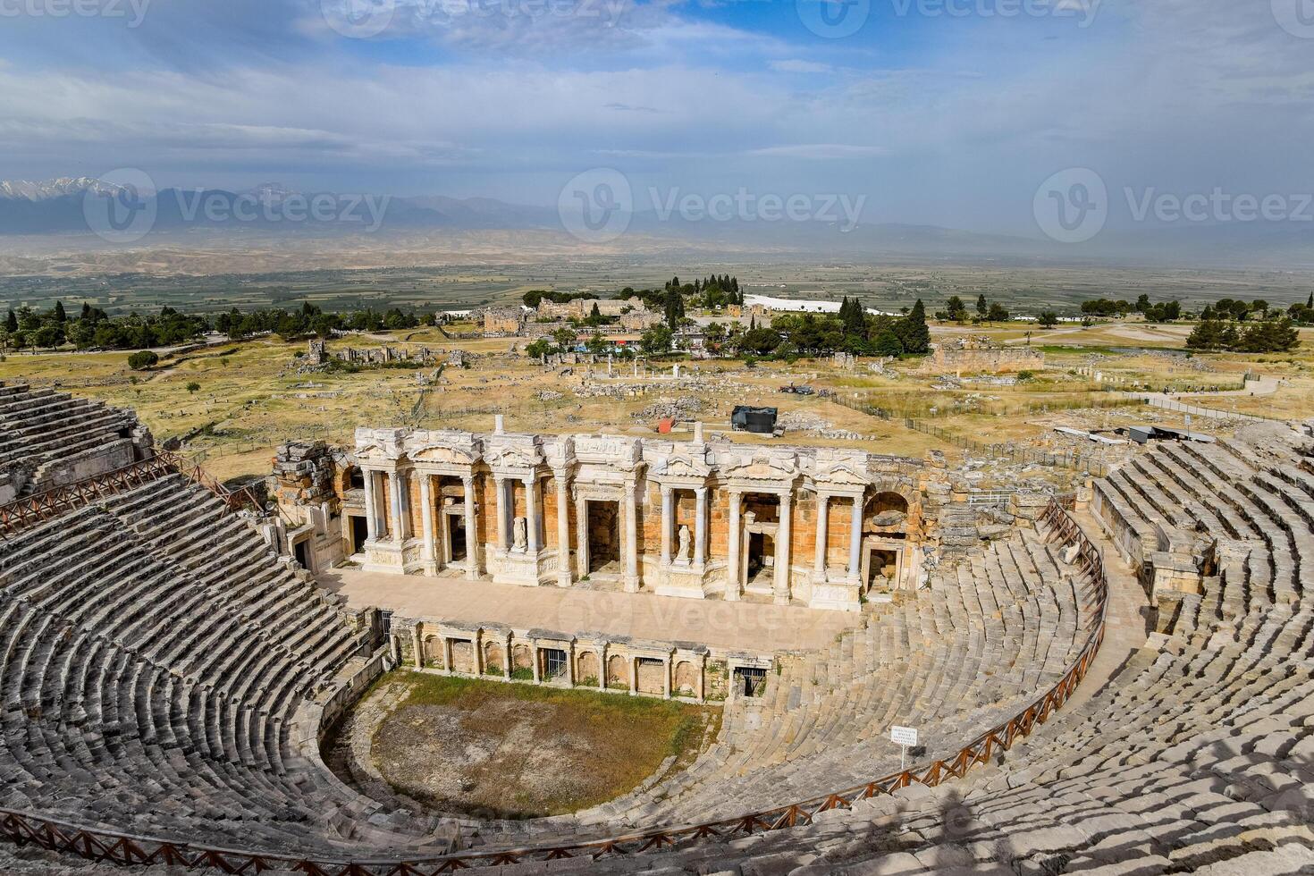 Ancient antique amphitheater in city of Hierapolis in Turkey. Steps and antique statues with columns in the amphitheater photo