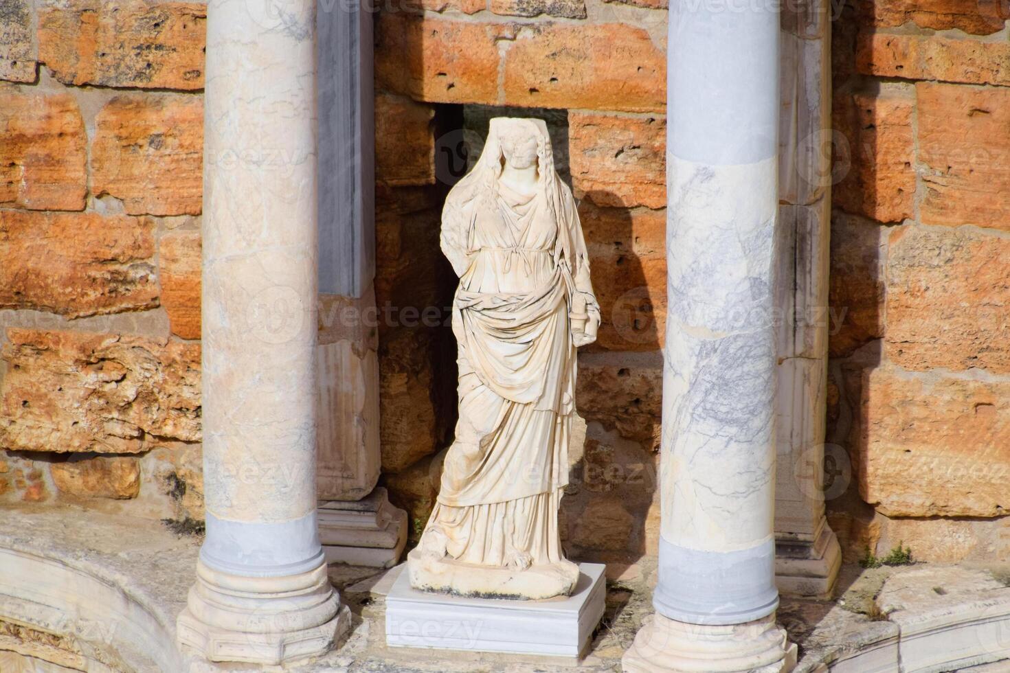 Marble statues at the columns of the amphitheater in Hierapolis, Turkey. photo