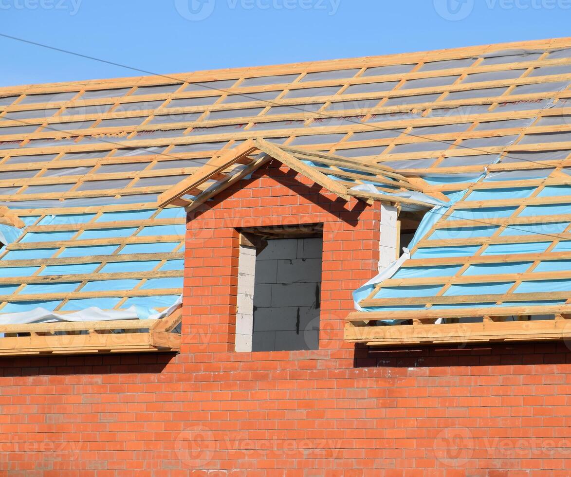 Construction of the roof of a new house. Wooden bars and vapor barrier photo