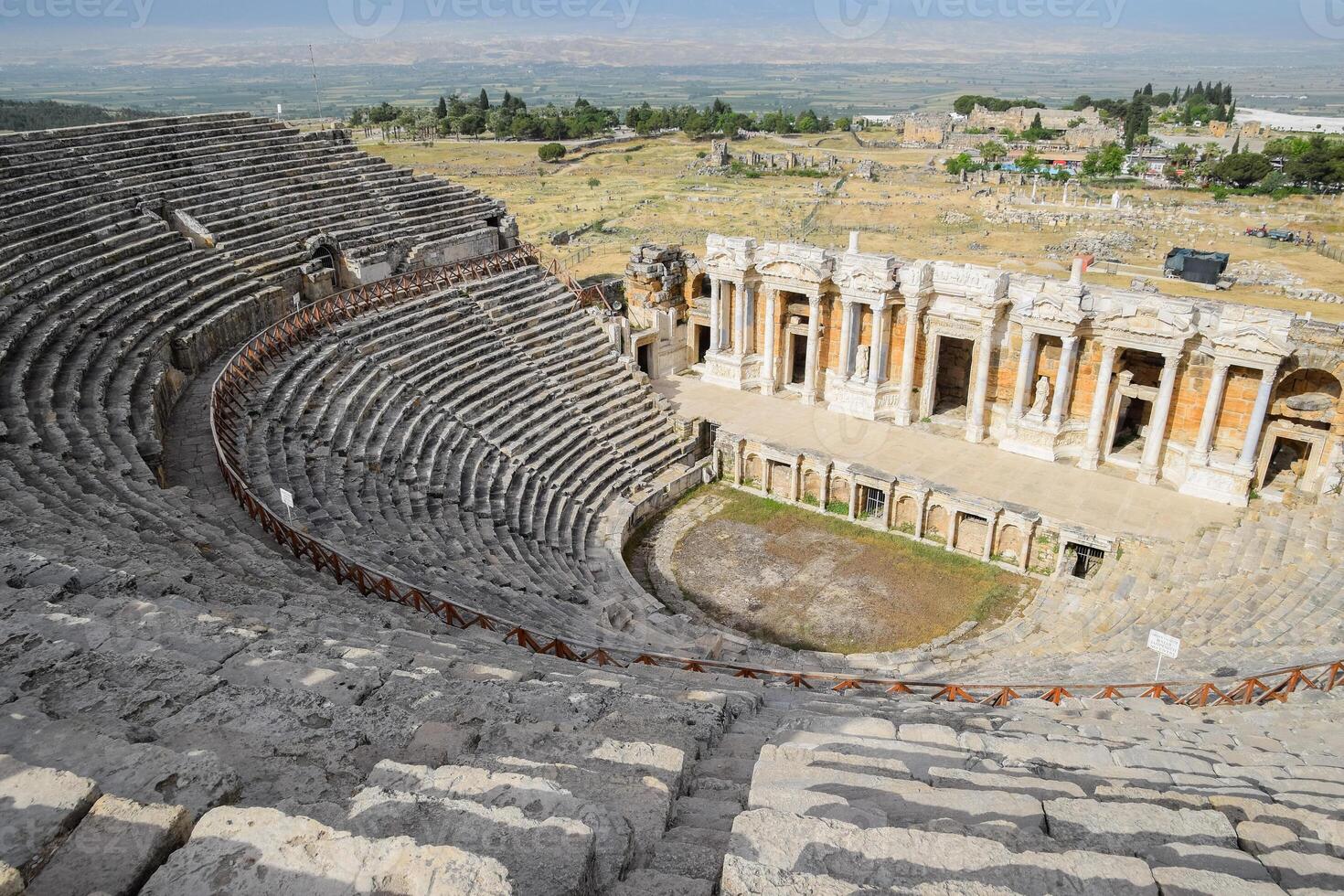 Ancient antique amphitheater in city of Hierapolis in Turkey. Steps and antique statues with columns in the amphitheater photo