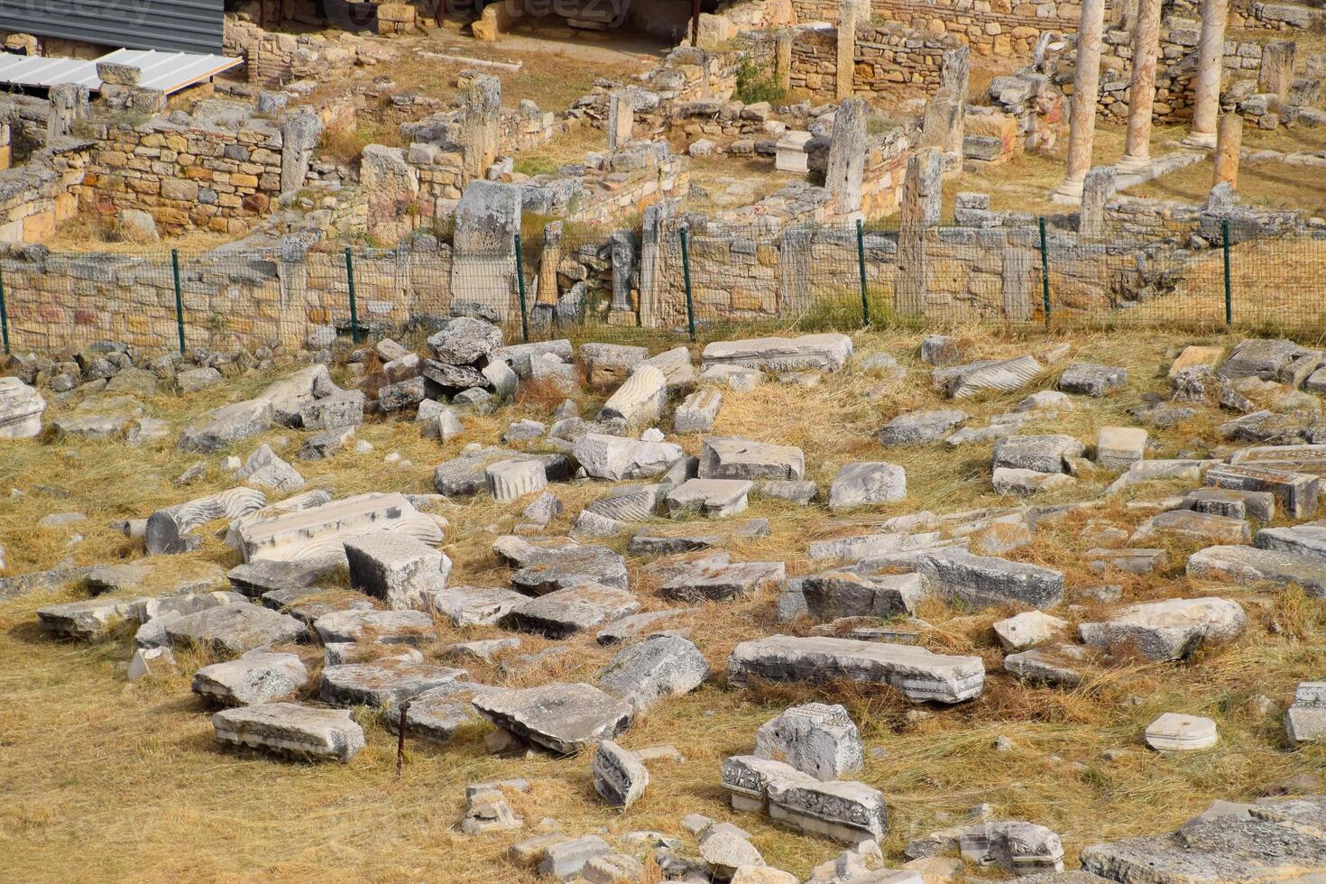 Top view of the excavation site in ruined ancient city of Hierapolis. The remains of destroyed buildings and columns. photo