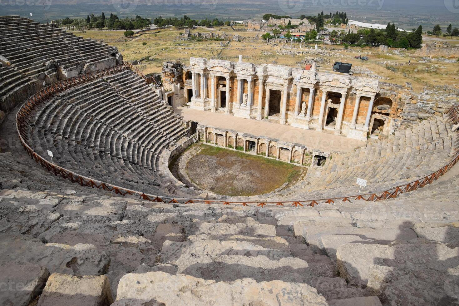 Ancient antique amphitheater in city of Hierapolis in Turkey. Steps and antique statues with columns in the amphitheater photo