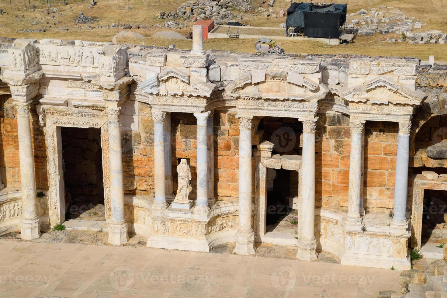 Ancient antique amphitheater in city of Hierapolis in Turkey. Steps and antique statues with columns in the amphitheater photo