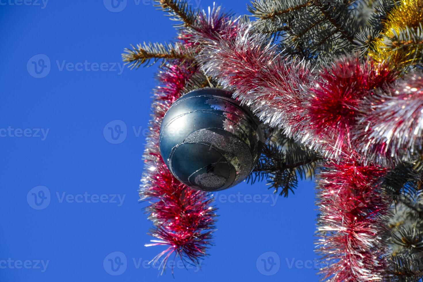 Decorations New Year tree. Tinsel and toys, balls and other decorations on the Christmas Christmas tree standing in the open air. photo