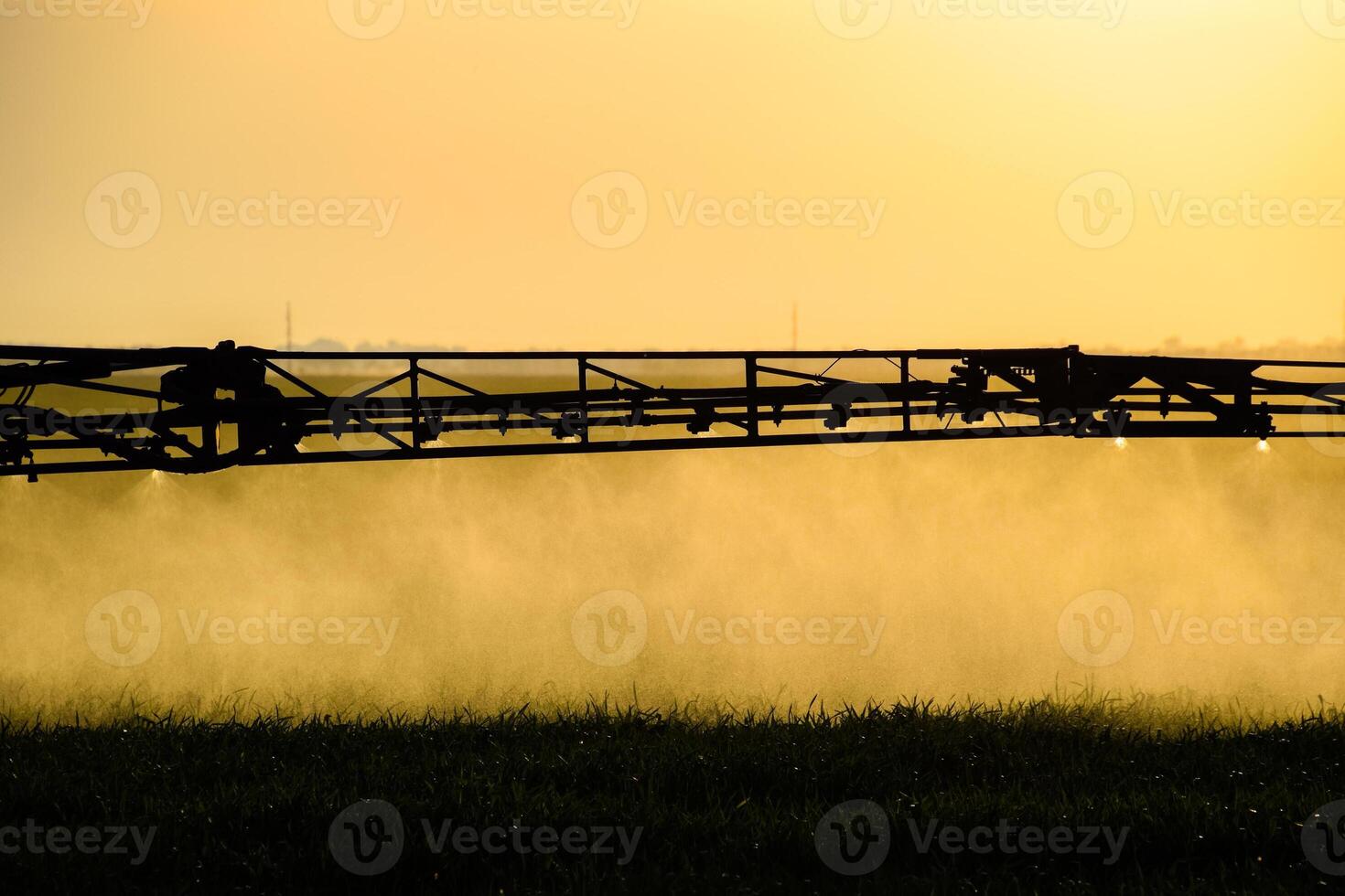 chorros de líquido fertilizante desde el tractor pulverizador. foto