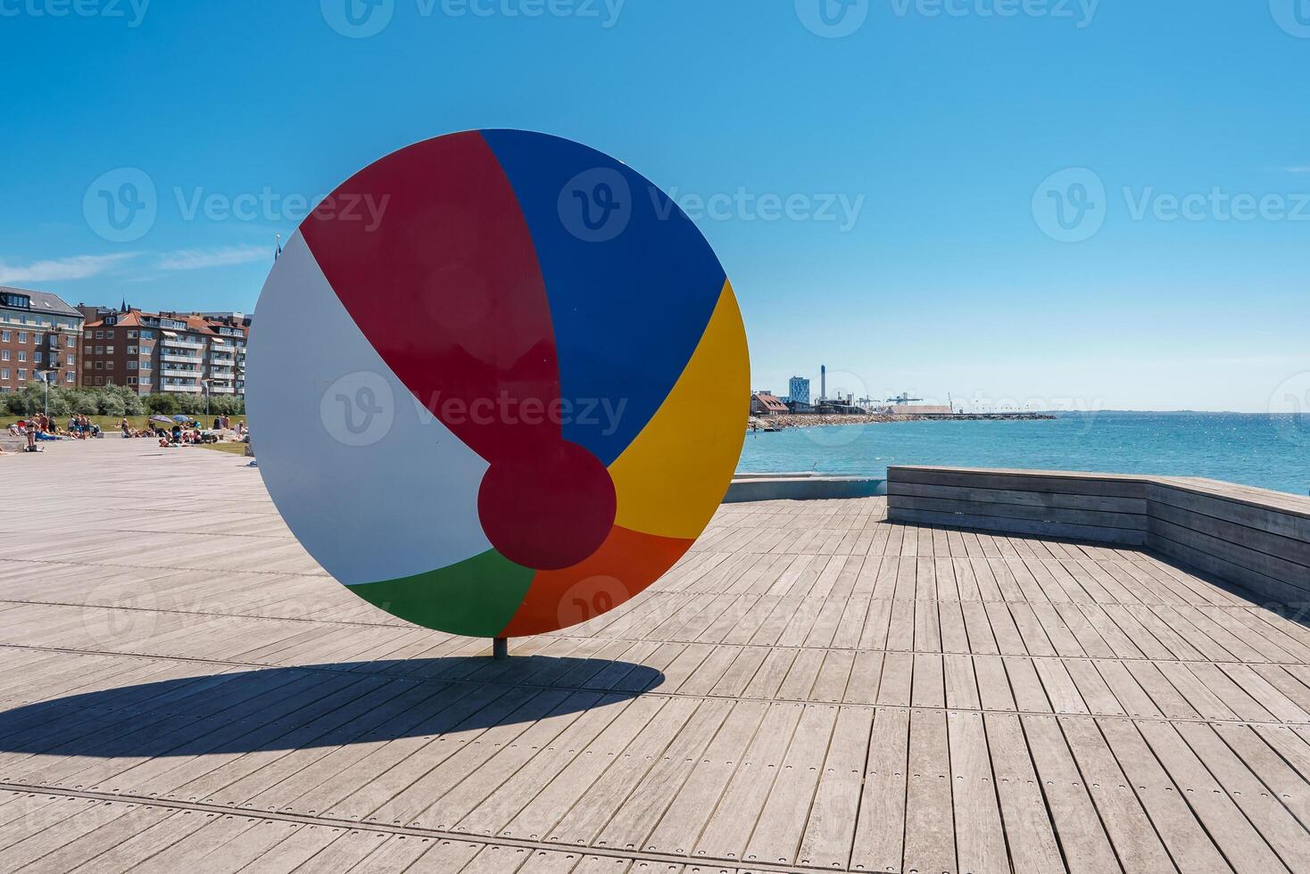 Vibrant Circular Sculpture Displayed on a Boardwalk in a Nordic City photo