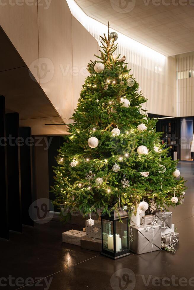 Elegant Christmas Tree Adorned with Warm Lights, Set in a Modern Interior Space photo