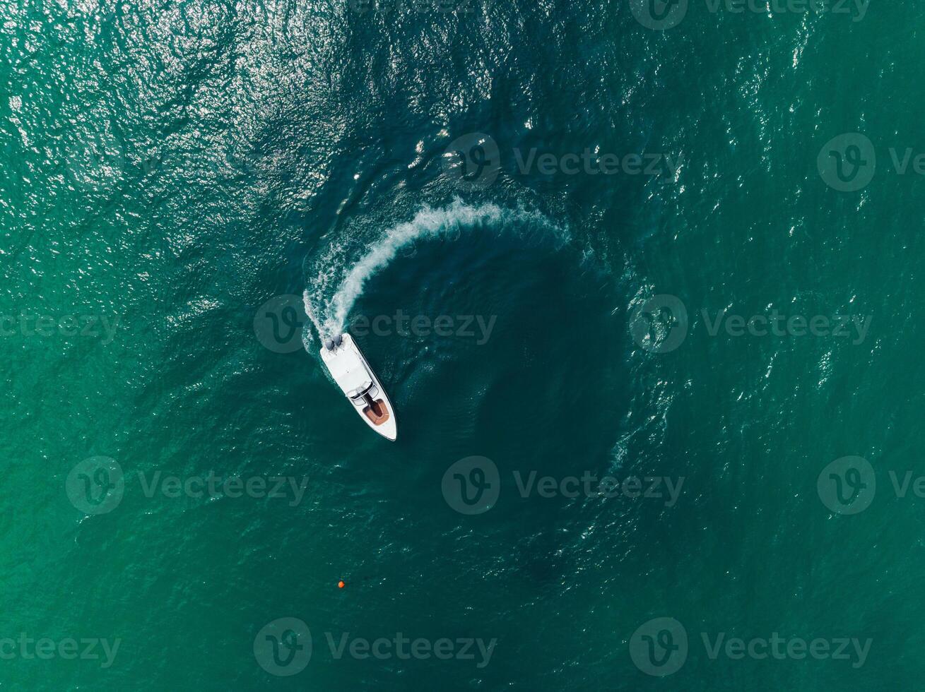 an aerial view of a boat traveling through the ocean photo