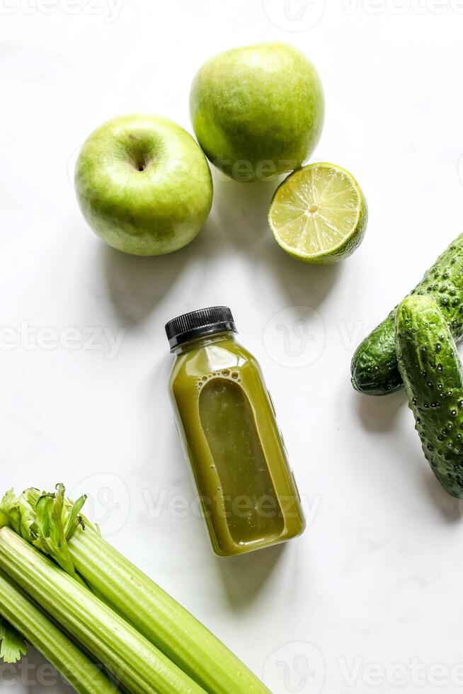 Bottle of green smoothie with celery and apple on white background photo