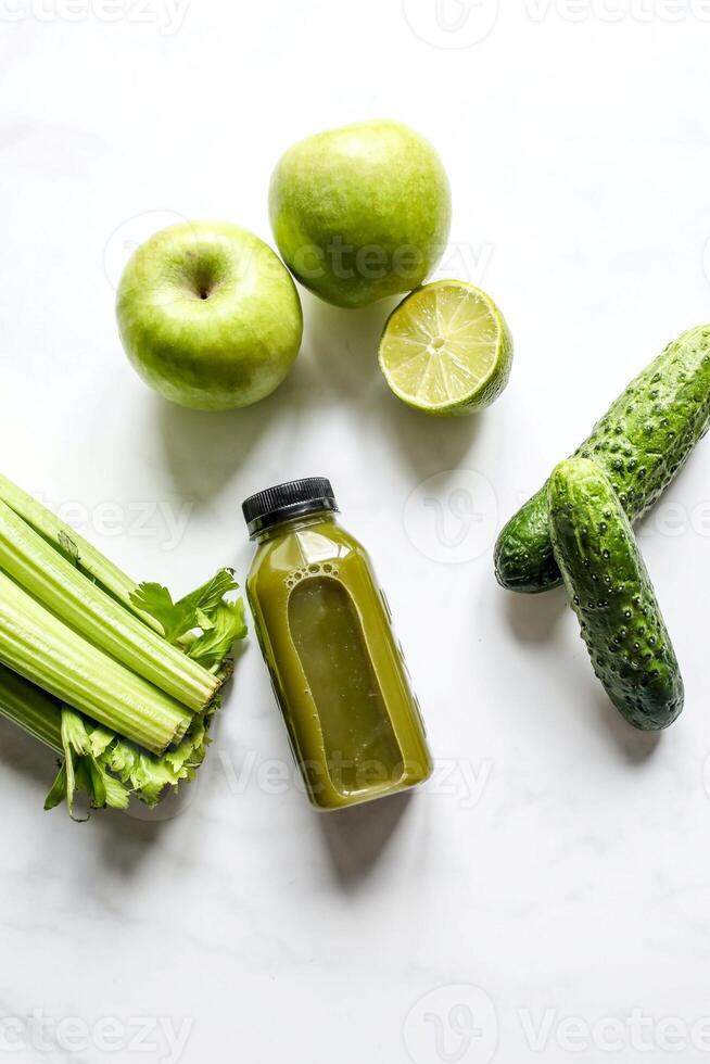 botella de verde zalamero con apio y manzana en blanco antecedentes foto