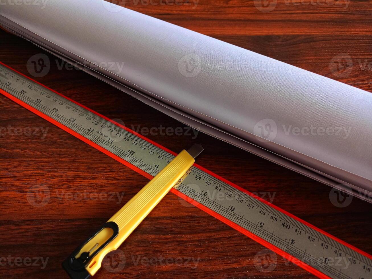 Paper, cutter and ruler on the work table photo